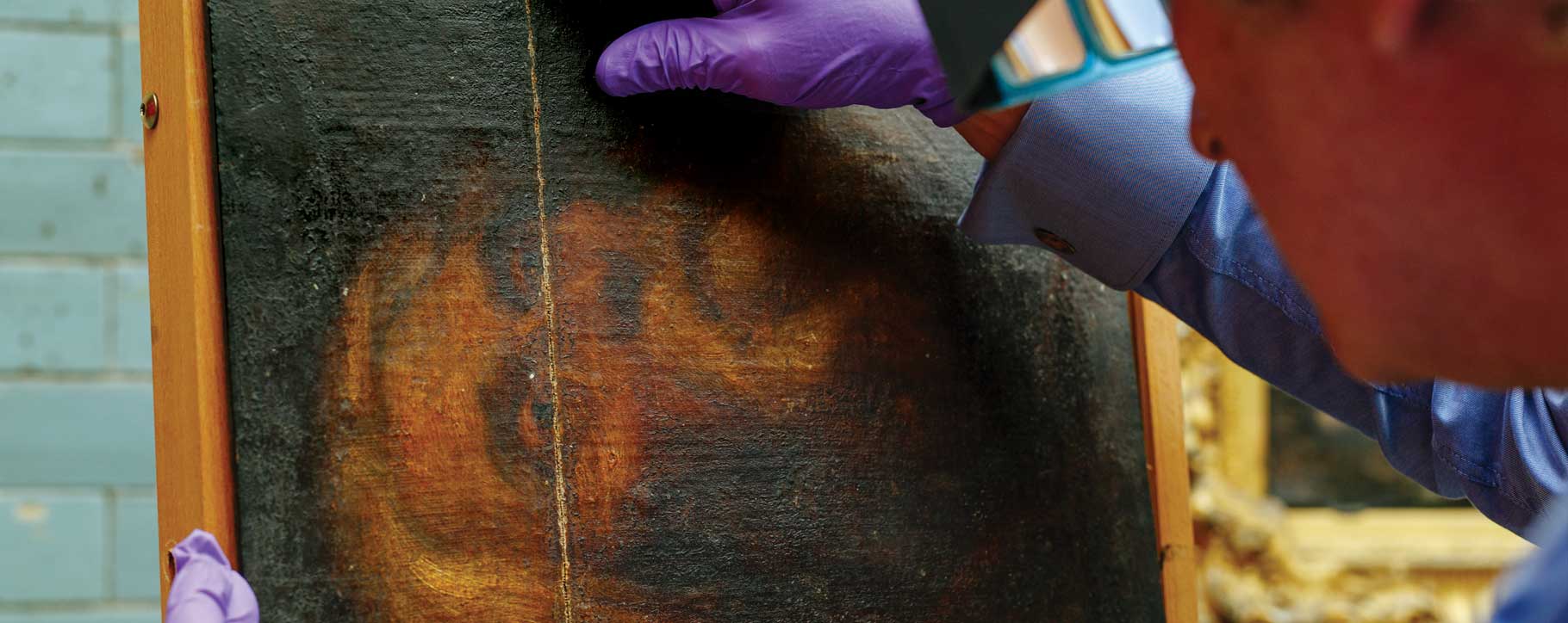 Conservator analysing oil painting
