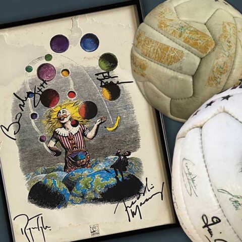 Two aged footballs and a signed poster featuring a juggling clown. Memorabilia and collectibles