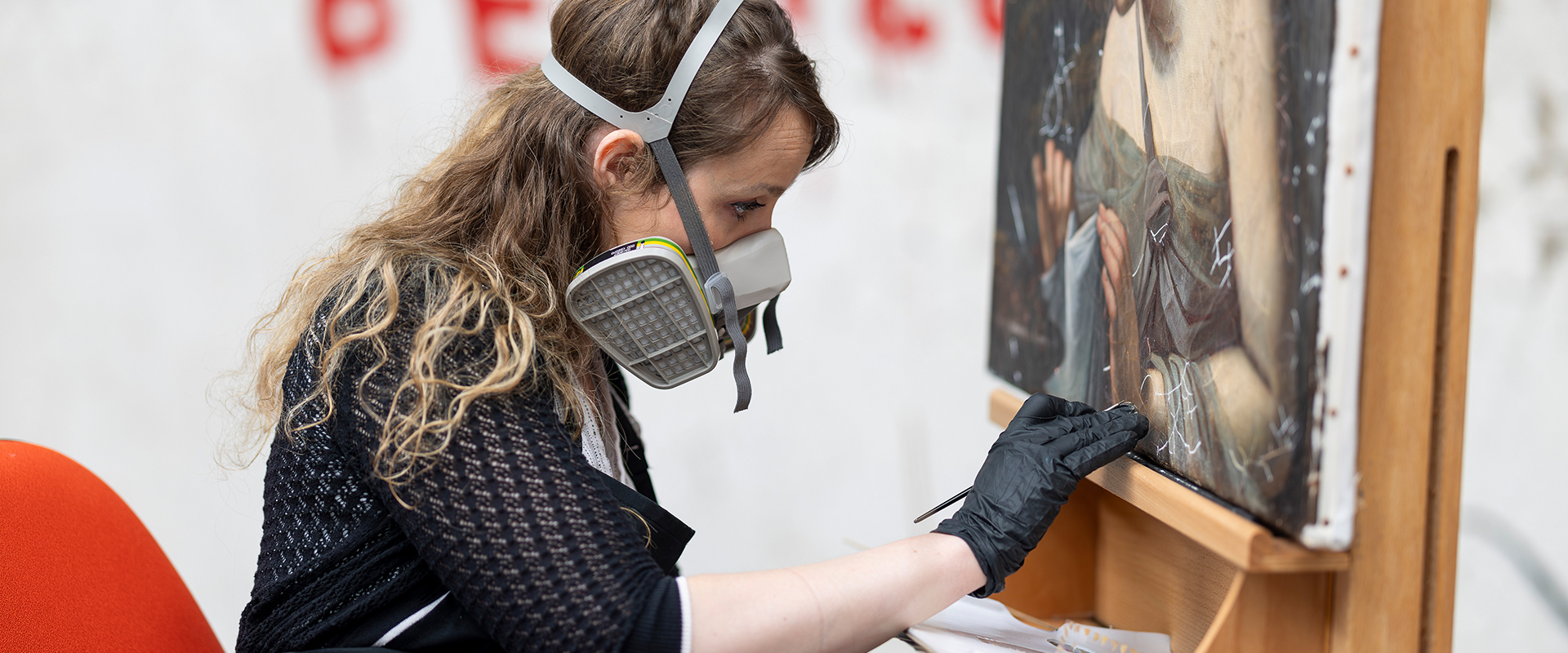 Conservator retouching a damaged painting